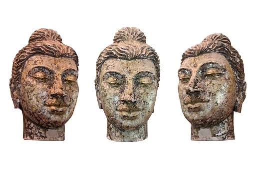 Three wooden Buddha sculptures of heads on a white background