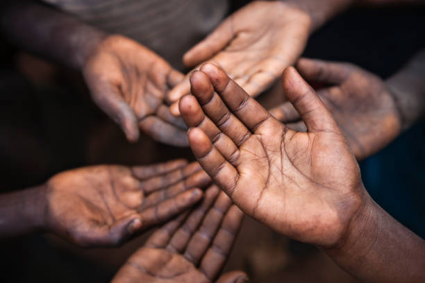 Poor African children keeping their hands up - asking for food. Many African children suffer from poverty - 20% of Africa’s children will die before the age of five.  Every day 30,000 children die from a combination of disease- infested water and malnutrition.