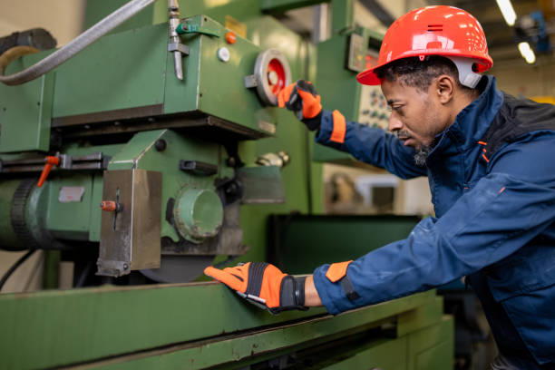 istock A dark-skinned industrial worker prepares a metalworking machine for work 1536109023