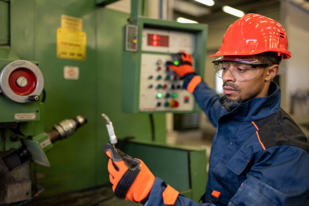 istock A dark-skinned industrial worker prepares a metalworking machine for work 1536109039