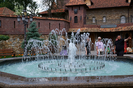 Kamensk-Shakhtinsky, Russia, July 2023. A medieval-style building on the territory of the Loga Park. Fountain in Loga Park on the central square.