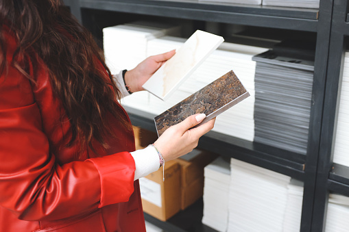 Interior designer at work: hands of an anonymous businessman selecting flooring samples.