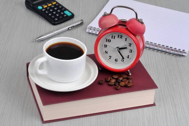 Coffee break Cup of coffee and alarm clock on a book tasse café stock pictures, royalty-free photos & images