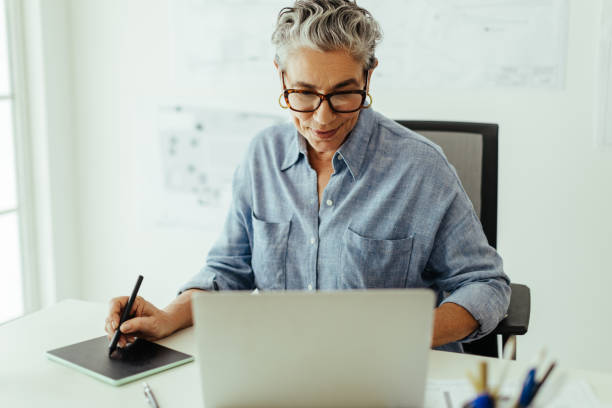 istock Creating graphic masterpieces: Senior designer drawing on a graphics tablet in her office 1536187075