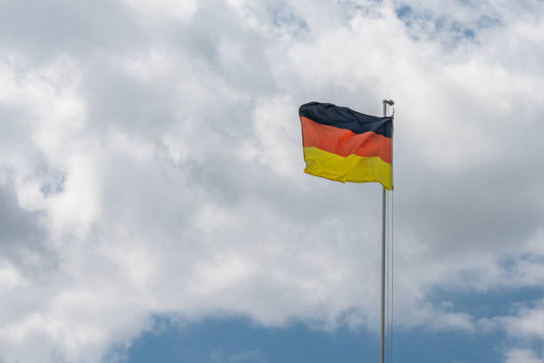istock German national flag flutters in the wind against a cloudy sky. 1536235144