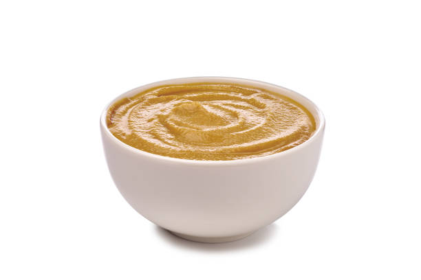 Mustard sauce in bowl on white background stock photo