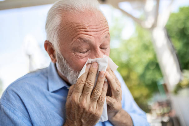 istock Sick senior man with napkin blowing his nose 1536249775