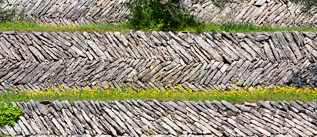 Dry-stone wall constructed with an opus spicatum (spiked work) system, a type of masonry used in Roman and medieval time. Sant’Ambrogio di Valpolicella, Italy. 