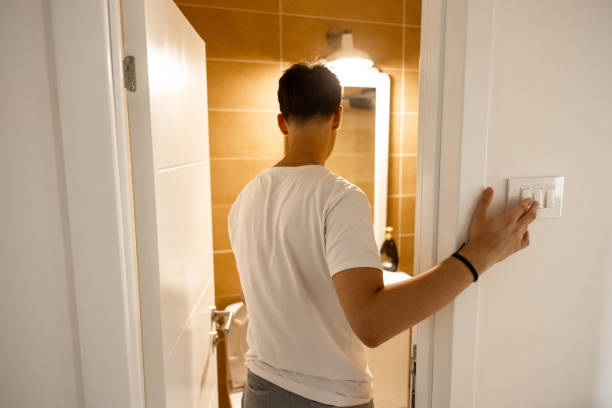 istock Unrecognizable teenage boy, turn on the light switch for the bathroom 1536373441