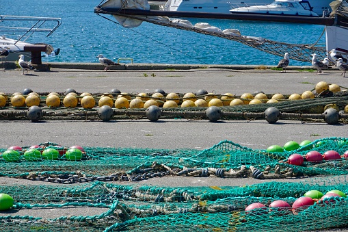Fishing nets. Fishing nets with colorful buoys. Fishing gear and tackle. Industrial fishing. Fishing nets in the port on the floor.