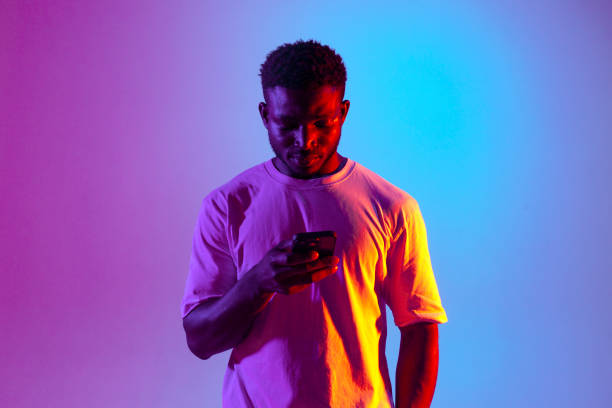 istock african american man using smartphone in neon lighting, the guy is typing and looking at the phone 1536452665