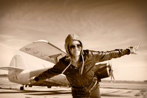 Happy young woman with raised hands  flying on airporte, Sepia photo.