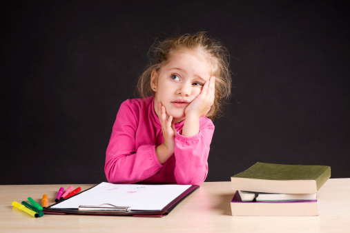 Little girl sitting in school desk