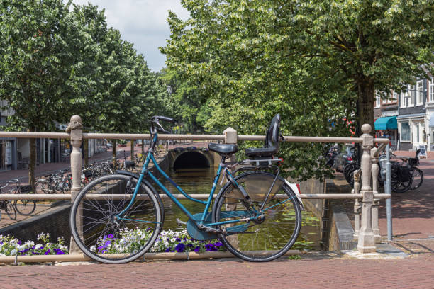 istock Bicycles are leaning against a fence on a bridge over a river 1536517112