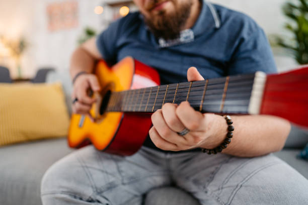 istock Young Man Playing Guitar At Home 1536520518