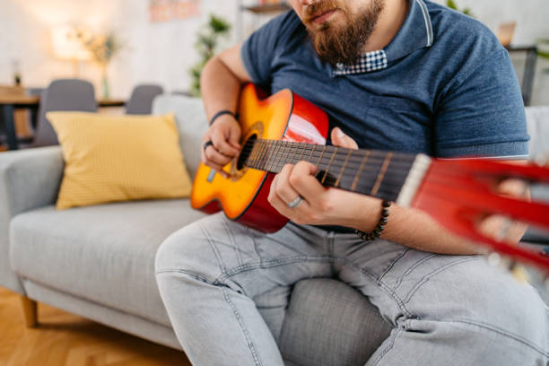 istock Young Man Playing Guitar At Home 1536525537