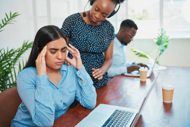 istock Young woman looks stressed while supervisor checks on her in office call centre 1536530359