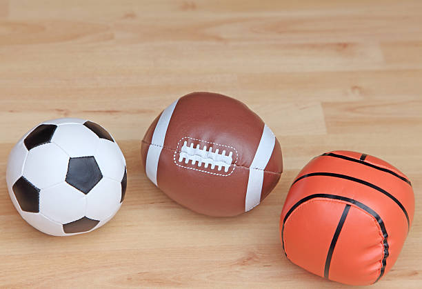 A soft orange football is lying on the window. A ball for classes with young children. The child left the toy on the windowsill