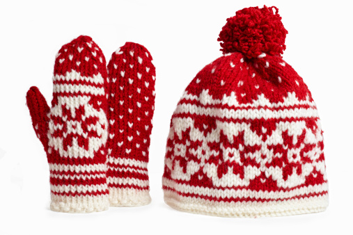 winter cap and mittens knitted with jackard and heart motifs. on white