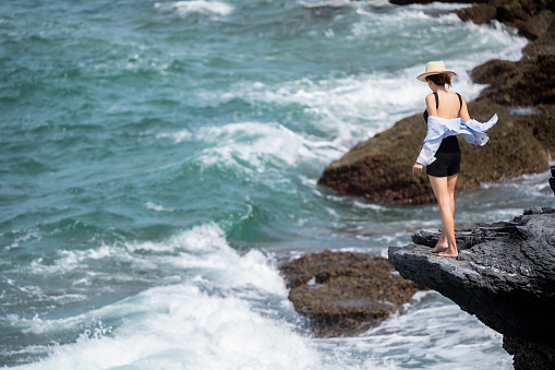 Women traveler enjoy the trip by standing to the natural cliff of the sea, summer moment on trip traveling