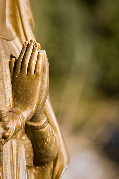 istock clasped hands,  statue of madonna 153667224