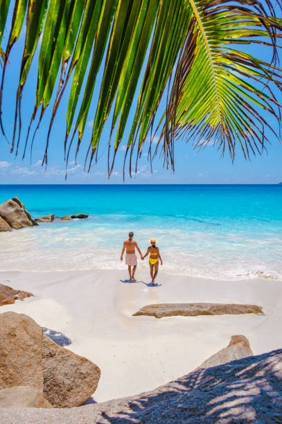 istock Praslin Seychelles tropical island with withe beaches and palm trees, couple men and women mid age on vacation at the Seychelles visiting the tropical beach of Anse Lazio Praslin Seychelles 1536686598