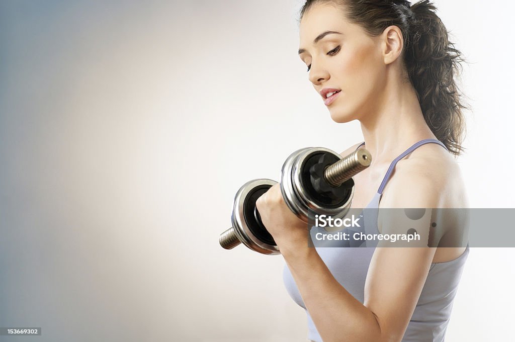 Woman flexing muscle while lifting weights a young girl going in for sport Activity Stock Photo