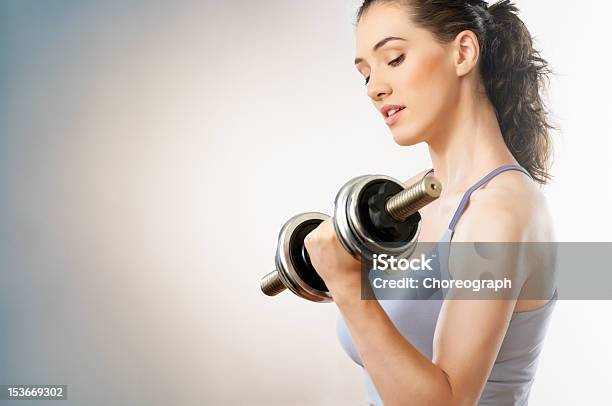 Woman Flexing Muscle While Lifting Weights Stock Photo - Download Image Now - Activity, Adult, Adults Only