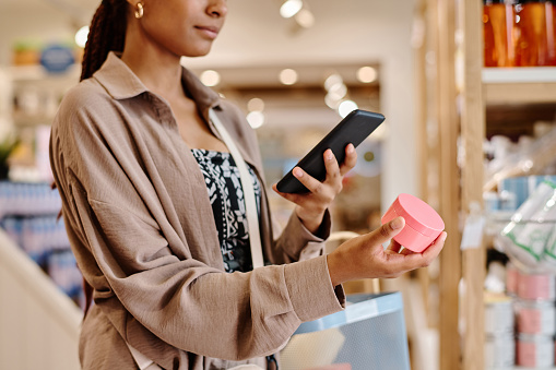 Woman making photo of cream on her smartphone