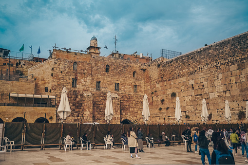 November 27, 2022 - Jerusalem, Israel. Tourist crowd and Jewish gather for Shacharit sunrise prayer at Old City Western Wailing Wall, holy place in Judaism. Temple Mount and Mount of Olives.