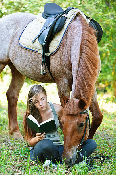 Jeune femme lisant livre avec cheval - Photo