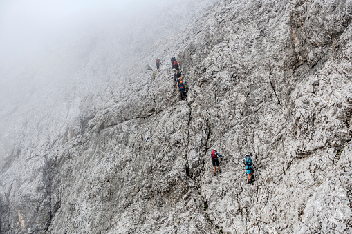 She is climbing up a steep ridge line