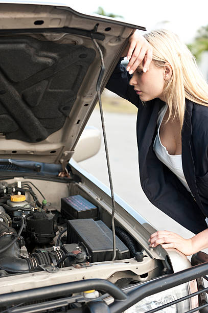Blonde woman watching her broken car