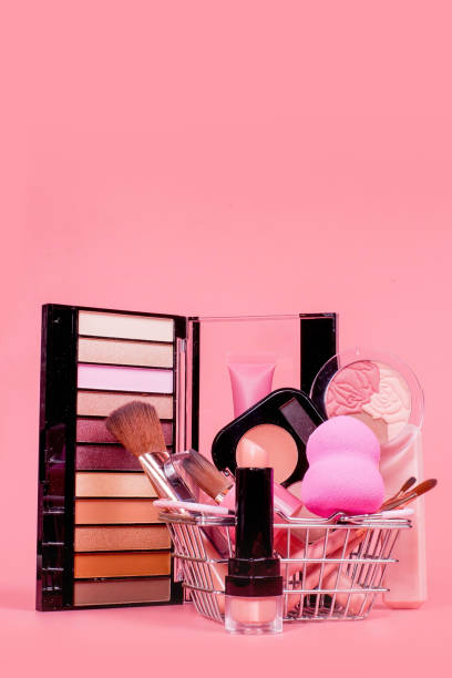 istock Creative concept with shopping trolley with makeup on a pink background. Perfume, sponge, brush, mascara, eye shadow, lip gloss in the basket 1536820129