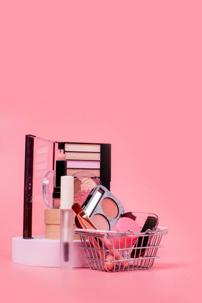istock Creative concept with shopping trolley with makeup on a pink background. Perfume, sponge, brush, mascara, eye shadow, lip gloss in the basket 1536820133