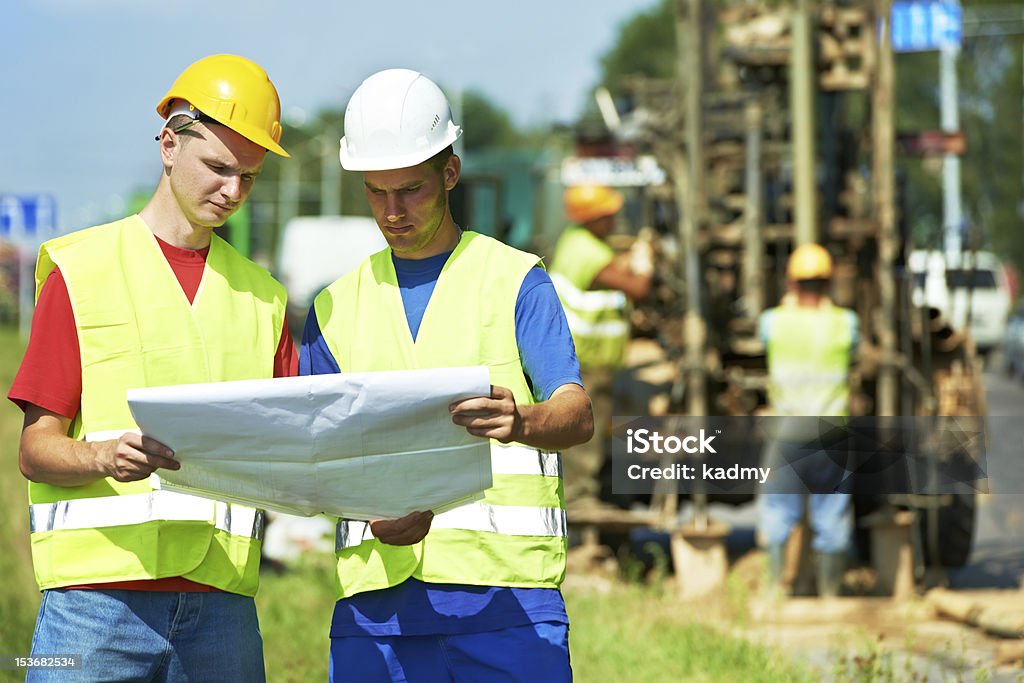 Ingenieros de construcción en sitio de construcción de obras en la carretera - Foto de stock de Geólogo libre de derechos