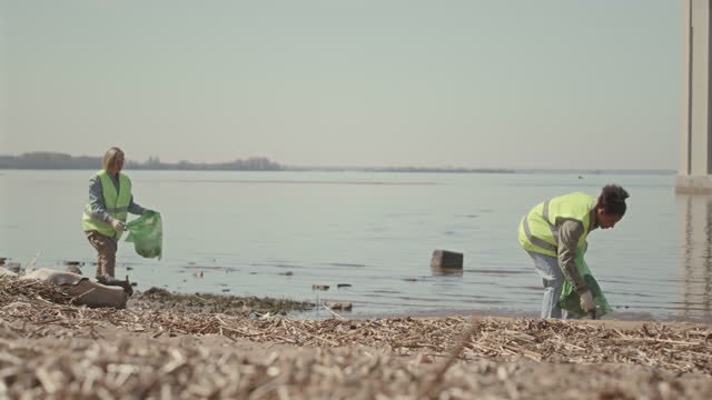 Environmental Volunteers Collecting Garbage on Shore