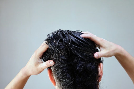 Back view of a man washing his hair