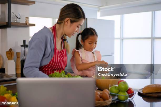 Mother And Daughter Make A Meal At Kitchen Stock Photo - Download Image Now - Family, 20-24 Years, 6-7 Years