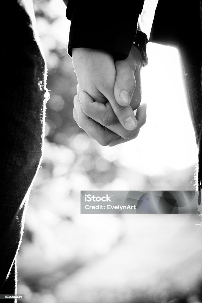 Black and white picture of two people holding hands a black and white image of a couple holding hands Bonding Stock Photo