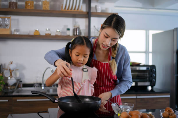 Mother and daughter make a meal at kitchen. stock photo