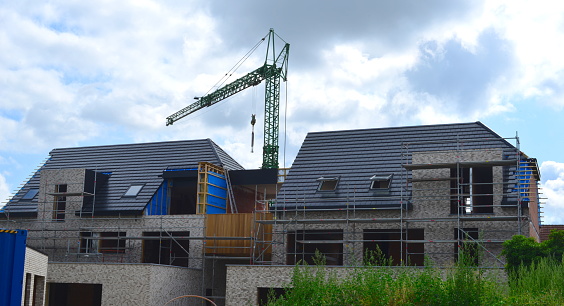 Leuven, Vlaams-Brabant, Belgium - July 12, 2023: rural densification. From demolition of a terraced house to building an apartment complex of 7 units. Installing wood panels outdoor on roof side