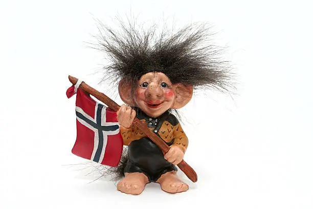 figurine of smiling troll hanging a flag at his arms isolated on a white, norway