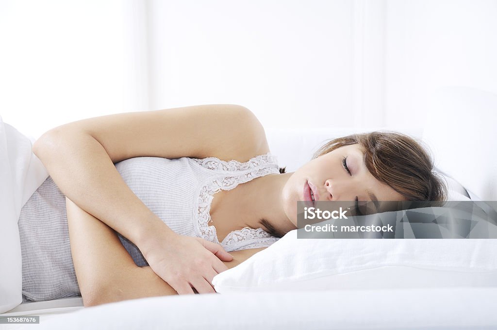 young woman sleeping on the bed young woman sleeping on the bed with white background Adult Stock Photo