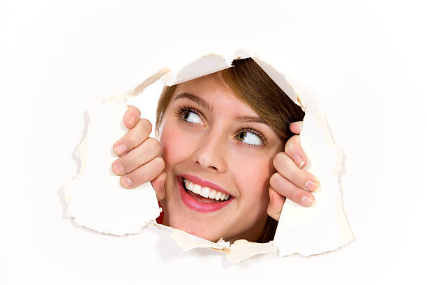 istock Young woman peeping through hole on paper 153688228