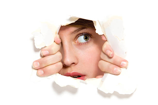 Looking through paper hole http://www.edkafelek.com/people.jpg shy stock pictures, royalty-free photos & images