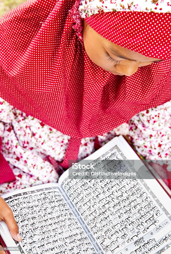 Child Reading Koran Muslim little girl reading Holy Book Koran Arabic Script Stock Photo