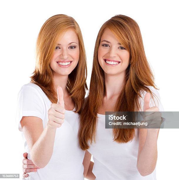 美しい 10 代の姉妹ギブ親指を立てる - 双子のストックフォトや画像を多数ご用意 - 双子, 白背景, カットアウト