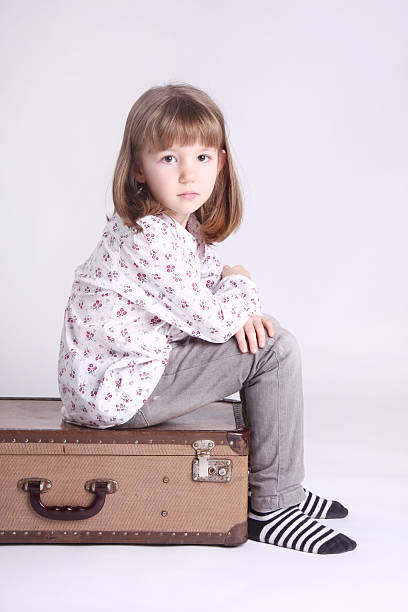 istock Cute little girl sitting on suitcase 153689231
