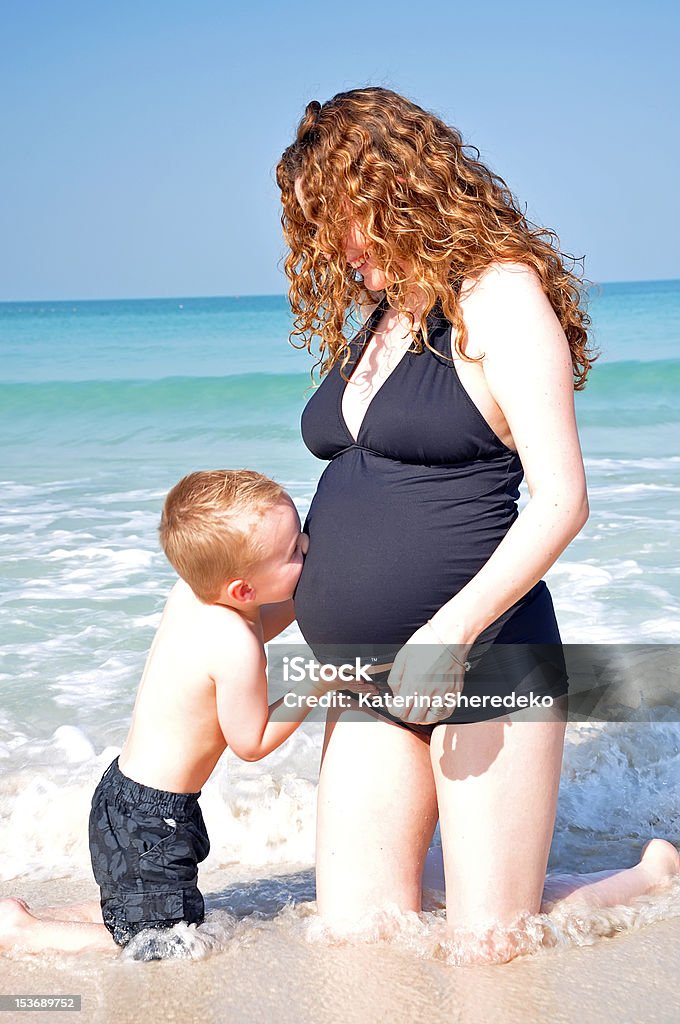 Menino beijando a barriga da Mãe grávida - Foto de stock de Abdome royalty-free